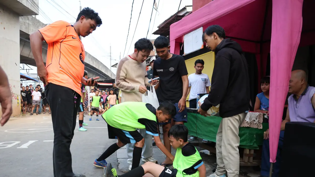 Anak-anak mengikuti pertandingan Turnamen Sepak Bola Liga Aspal U-13 di lapangan sederhana kawasan permukiman padat pinggir rel RT 09/RW 08, Menteng Jaya, Jakarta, Sabtu (27/6/2026). (Dery Ridwansah/ JawaPos.com)