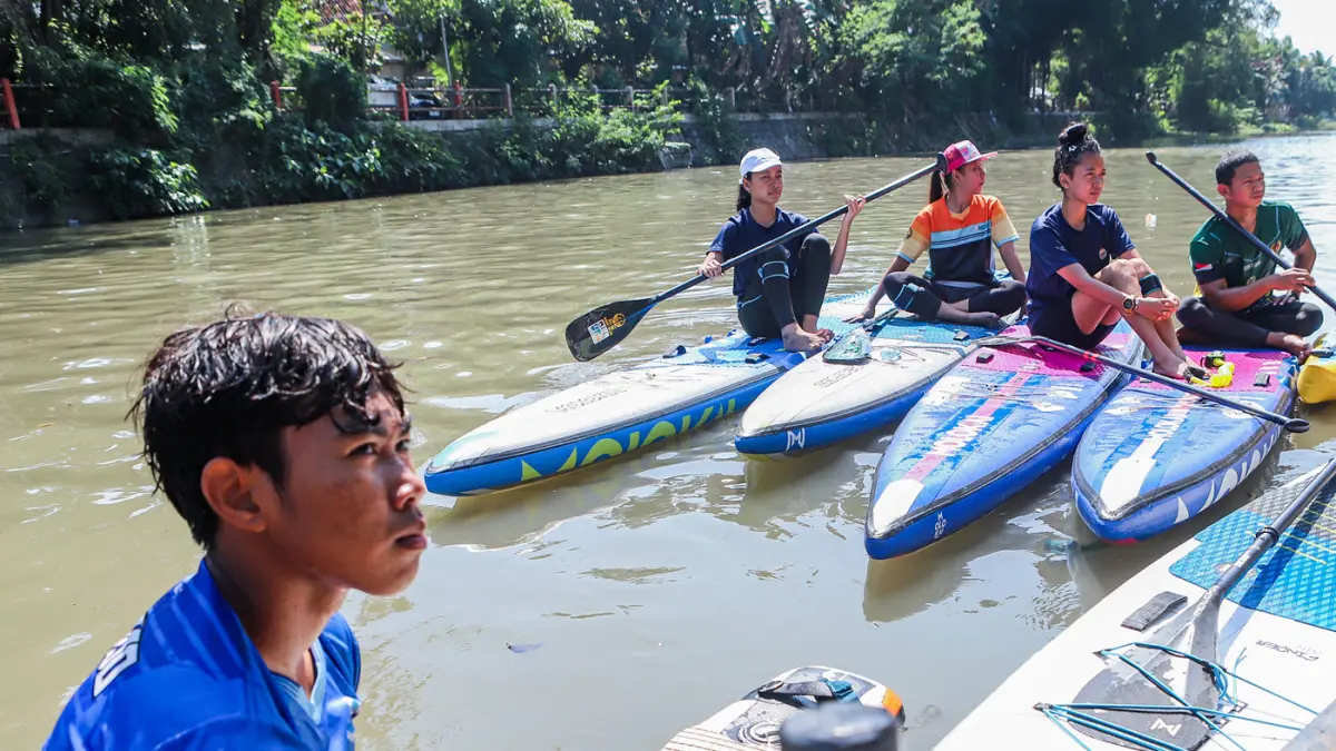 Peserta kompetisi stand up paddle melintas di Sungai Kalimas Kawasan Peneleh, Minggu (28/6/2026). (Riana Setiawan/Jawa Pos)