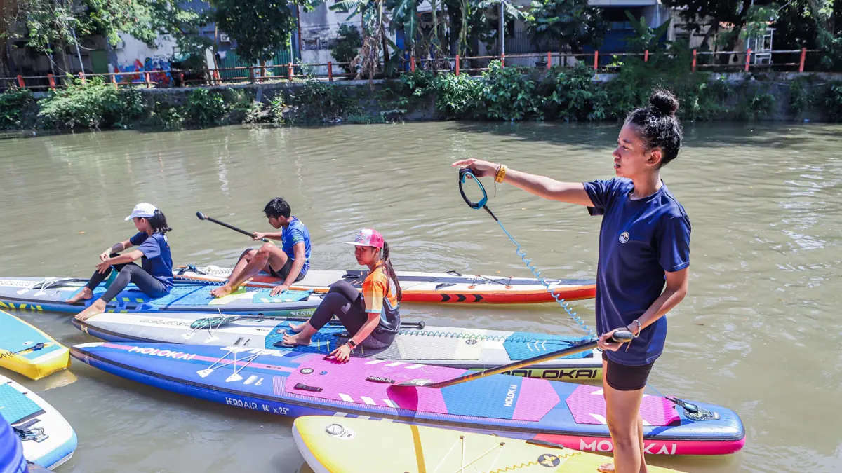Peserta kompetisi stand up paddle melintas di Sungai Kalimas Kawasan Peneleh, Minggu (28/6/2026). (Riana Setiawan/Jawa Pos)