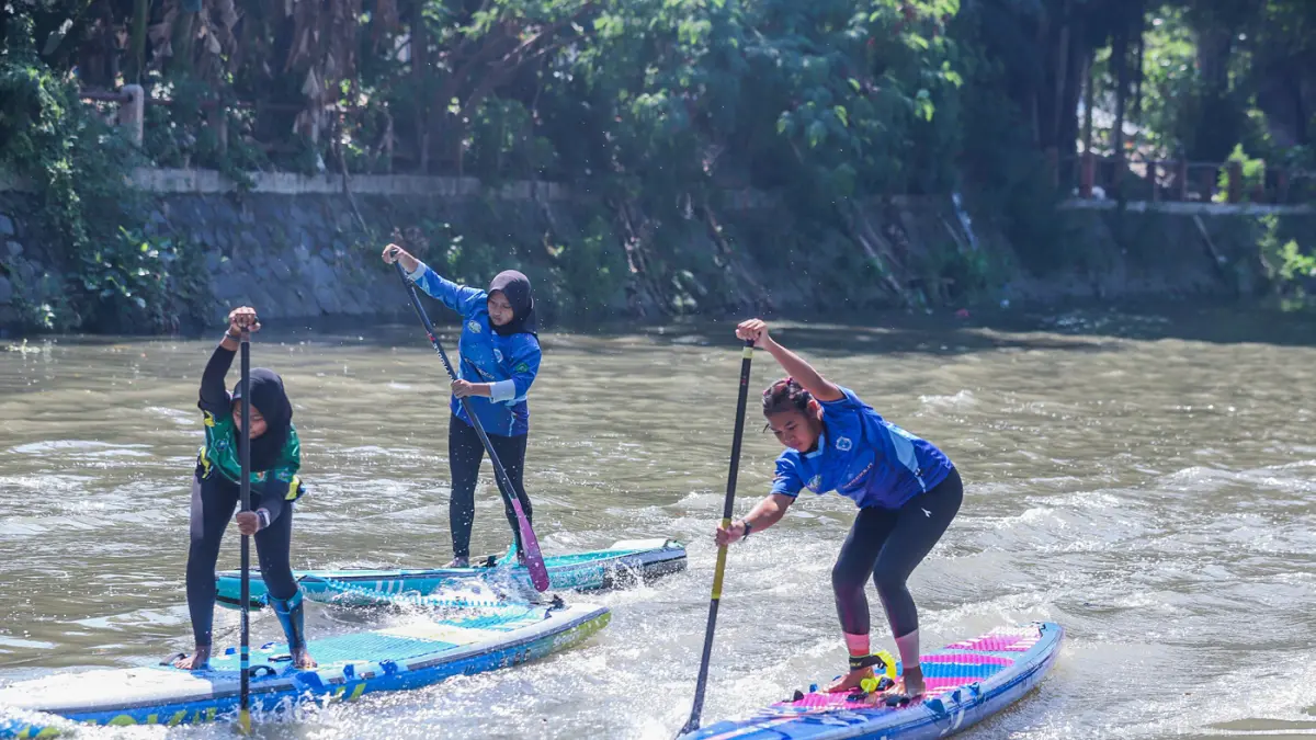Peserta kompetisi stand up paddle melintas di Sungai Kalimas Kawasan Peneleh, Minggu (28/6/2026). (Riana Setiawan/Jawa Pos)