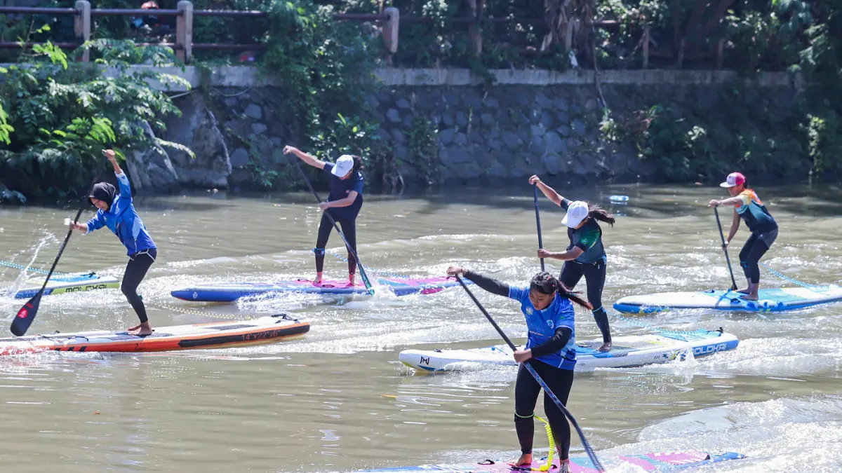 Peserta kompetisi stand up paddle melintas di Sungai Kalimas Kawasan Peneleh, Minggu (28/6/2026). (Riana Setiawan/Jawa Pos)