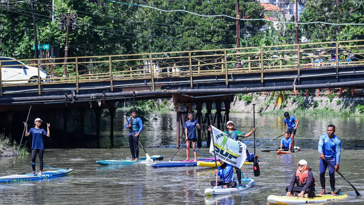 Peserta kompetisi stand up paddle melintas di Sungai Kalimas Kawasan Peneleh, Minggu (28/6/2026). (Riana Setiawan/Jawa Pos)