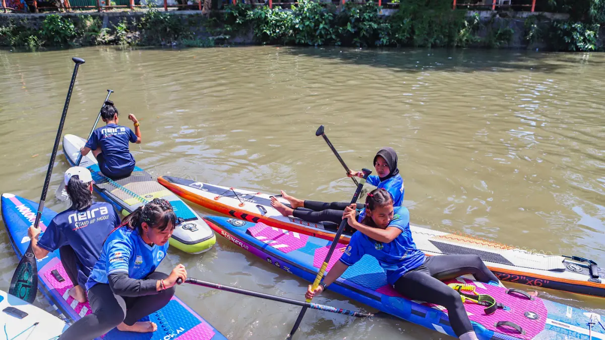 Peserta kompetisi stand up paddle melintas di Sungai Kalimas Kawasan Peneleh, Minggu (28/6/2026). (Riana Setiawan/Jawa Pos)