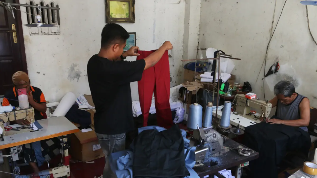 Pekerja menyelesaikan produksi seragam sekolah di rumah konveksi, Semarang, Jawa Tengah, Rabu (1/7/2026). (Nur Chamim/Jawa Pos Radar Semarang)