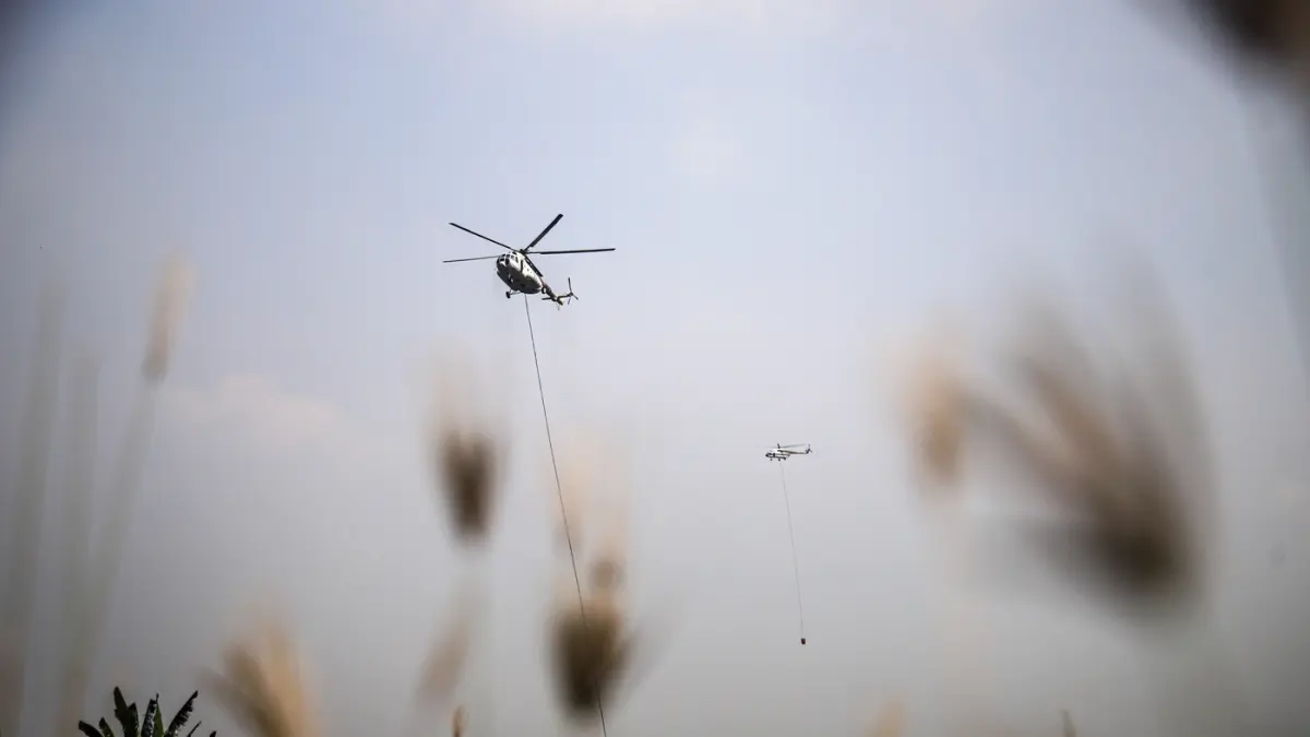 Helikopter MI-8AMT milik Badan Nasional Penanggulangan Bencana (BNPB) menjatuhkan air untuk memadamkan kebakaran sampah di Tempat Pembuangan Akhir (TPA) Jatiwaringin, Tangerang, Jumat (04/072026). (Hanung Hambara/Jawa Pos)