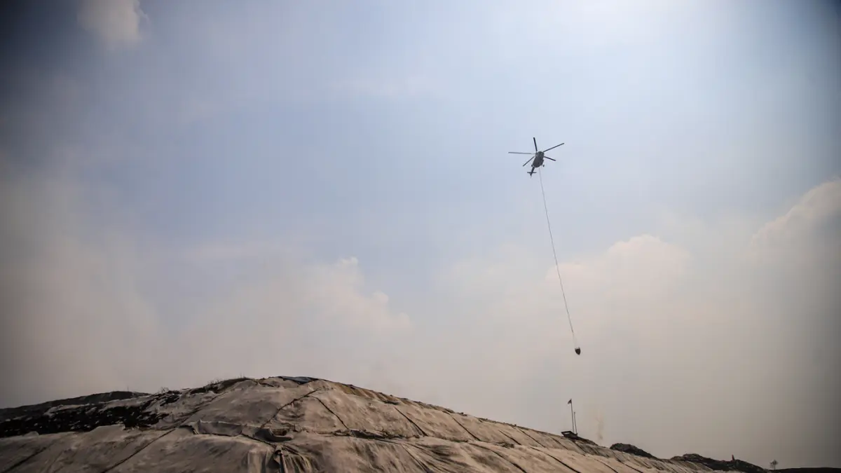Helikopter MI-8AMT milik Badan Nasional Penanggulangan Bencana (BNPB) menjatuhkan air untuk memadamkan kebakaran sampah di Tempat Pembuangan Akhir (TPA) Jatiwaringin, Tangerang, Jumat (04/072026). (Hanung Hambara/Jawa Pos)