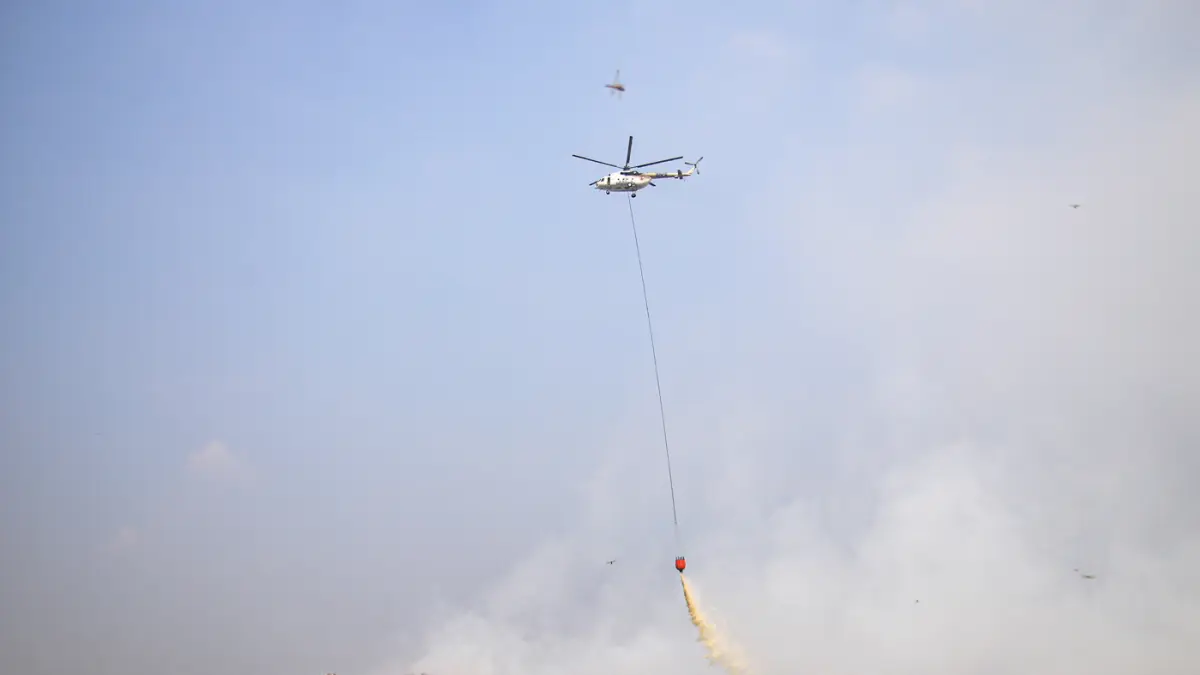 Helikopter MI-8AMT milik Badan Nasional Penanggulangan Bencana (BNPB) menjatuhkan air untuk memadamkan kebakaran sampah di Tempat Pembuangan Akhir (TPA) Jatiwaringin, Tangerang, Jumat (04/072026). (Hanung Hambara/Jawa Pos)