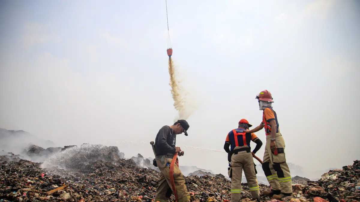 Petugas Pemadam Kebakaran dibantu dengan dua halikopter milik BNPB memadamkan titik api di TPA Jatiwaringin, Tangerang, Jumat (03/07/2026). (Hanung Hambara/Jawa Pos)