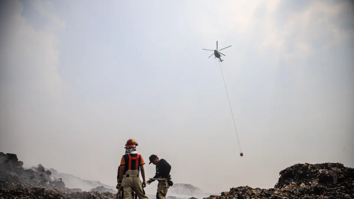 Petugas Pemadam Kebakaran dibantu dengan dua halikopter milik BNPB memadamkan titik api di TPA Jatiwaringin, Tangerang, Jumat (03/07/2026). (Hanung Hambara/Jawa Pos)