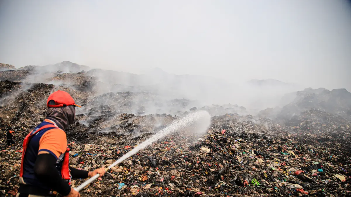 Petugas Pemadam Kebakaran dibantu dengan dua halikopter milik BNPB memadamkan titik api di TPA Jatiwaringin, Tangerang, Jumat (03/07/2026). (Hanung Hambara/Jawa Pos)
