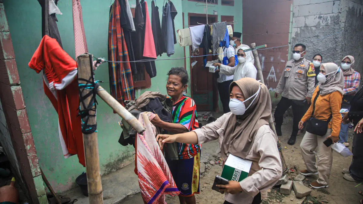 Sejumlah ibu-ibu kader PKK dibantu aparat desa mengevakuasi penduduk Desa Tanjakan Mekar, Rajeg, Tangerang, Jumat (03/07/3026). (Hanung Hambara/Jawa Pos)