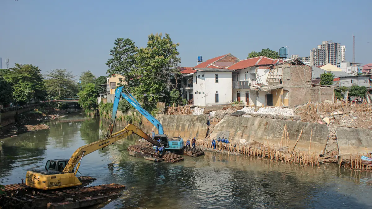 Sejumlah anggota Dinas Sumber Daya Air (SDA) memasang bronjong di talud sungai Ciliwung yang ambrol di Jakarta, Senin (06/07/2026). (Hanung Hambara/Jawa Pos)