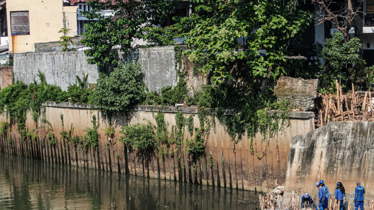 Sejumlah anggota Dinas Sumber Daya Air (SDA) memasang bronjong di talud sungai Ciliwung yang ambrol di Jakarta, Senin (06/07/2026). (Hanung Hambara/Jawa Pos)