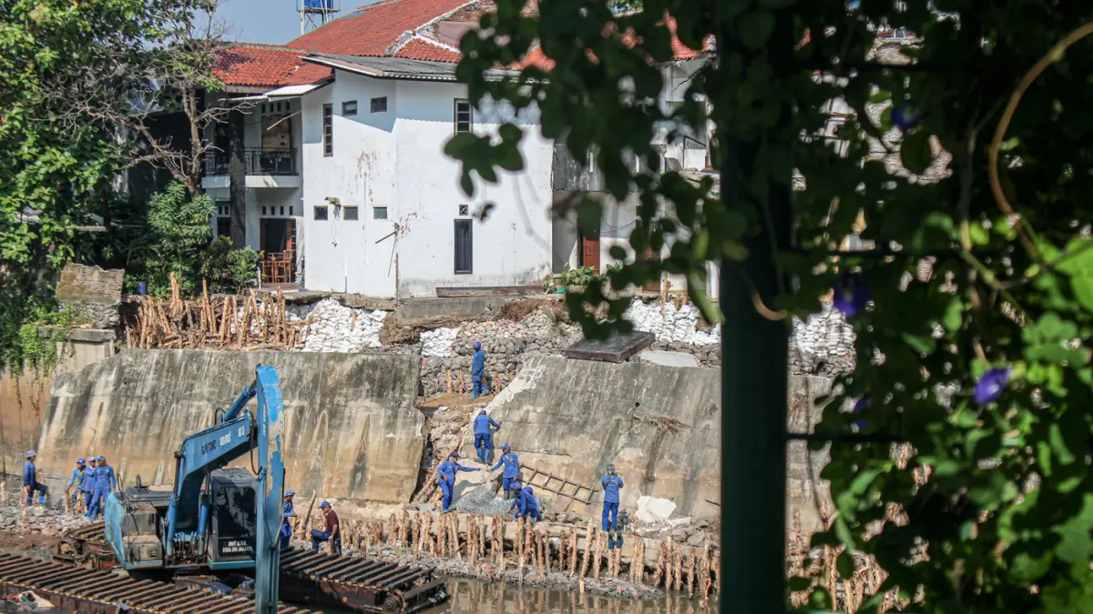 Sejumlah anggota Dinas Sumber Daya Air (SDA) memasang bronjong di talud sungai Ciliwung yang ambrol di Jakarta, Senin (06/07/2026). (Hanung Hambara/Jawa Pos)