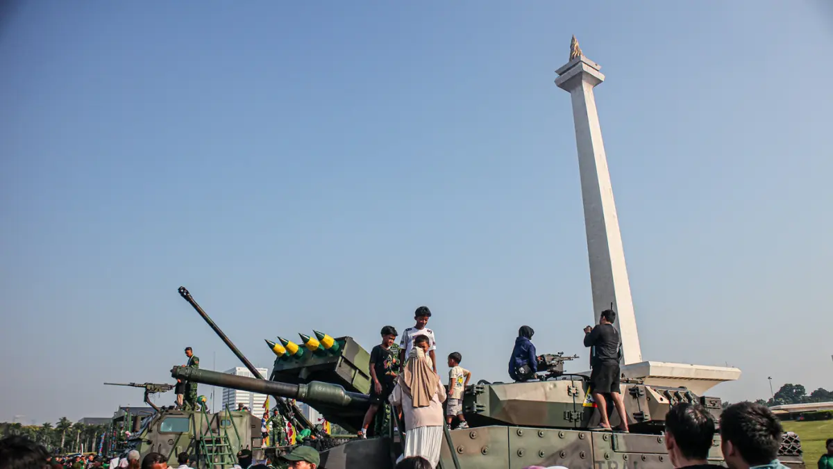 Sejumlah pengunjung berfoto di depan Alat Utama Sistem Senjata (Alutsista) di Monas, Jakarta, Minggu (05/07/2027). (Hanung Hambara/Jawa Pos)