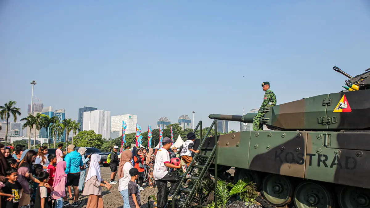 Sejumlah pengunjung berfoto di depan Alat Utama Sistem Senjata (Alutsista) di Monas, Jakarta, Minggu (05/07/2027). (Hanung Hambara/Jawa Pos)