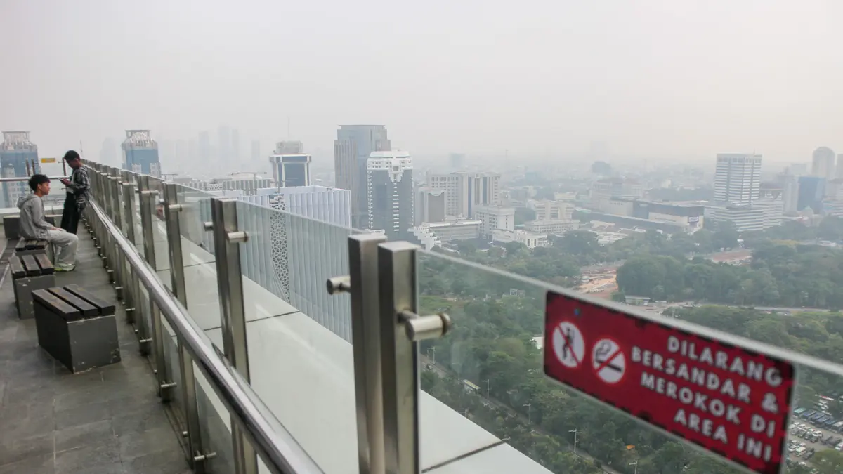Sejumlah warga melihat Tugu Monas dari Perpustakaan Nasional, Jakarta, Selasa (07/07/2026). (Hanung Hambara/Jawa Pos)