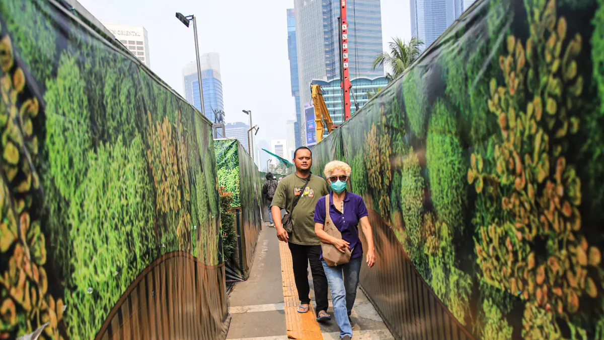 Warga memakai masker saat beraktiritas di luar ruangan di sekitar Bundaran HI, Jakarta, Selasa (07/07/2026). (Hanung Hambara/Jawa Pos)