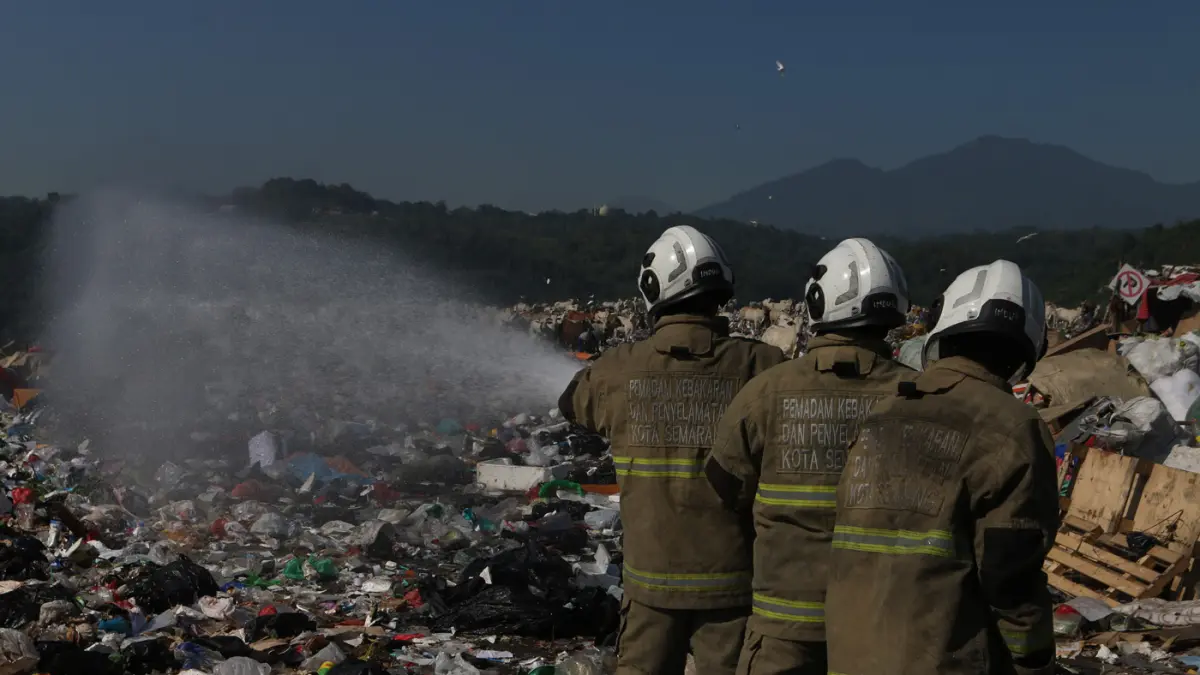 Petugas pemadam kebakaran menyiramkan air ke arah sampah saat simulasi pengendalian gas metana dalam apel kesiapsiagaan dan antisipasi bencana kebakaran di Tempat Pemrosesan Akhir (TPA) Jatibarang, Semarang, Jawa Tengah, Kamis (9/7/2026). (Nur Chamim/Jawa