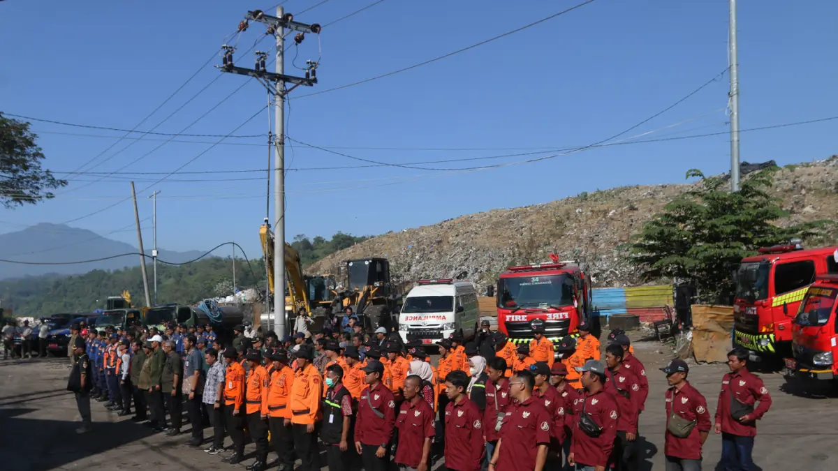 Petugas pemadam kebakaran menyiramkan air ke arah sampah saat simulasi pengendalian gas metana dalam apel kesiapsiagaan dan antisipasi bencana kebakaran di Tempat Pemrosesan Akhir (TPA) Jatibarang, Semarang, Jawa Tengah, Kamis (9/7/2026). (Nur Chamim/Jawa