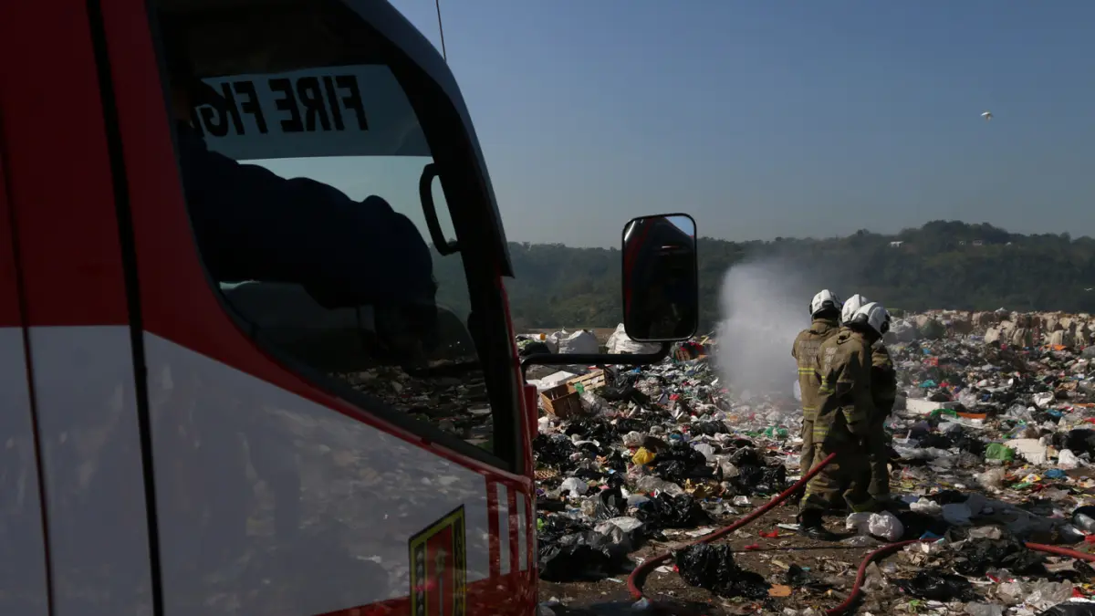 Petugas pemadam kebakaran menyiramkan air ke arah sampah saat simulasi pengendalian gas metana dalam apel kesiapsiagaan dan antisipasi bencana kebakaran di Tempat Pemrosesan Akhir (TPA) Jatibarang, Semarang, Jawa Tengah, Kamis (9/7/2026). (Nur Chamim/Jawa