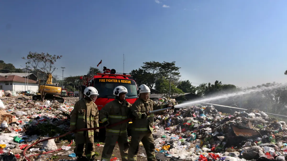 Petugas pemadam kebakaran menyiramkan air ke arah sampah saat simulasi pengendalian gas metana dalam apel kesiapsiagaan dan antisipasi bencana kebakaran di Tempat Pemrosesan Akhir (TPA) Jatibarang, Semarang, Jawa Tengah, Kamis (9/7/2026). (Nur Chamim/Jawa
