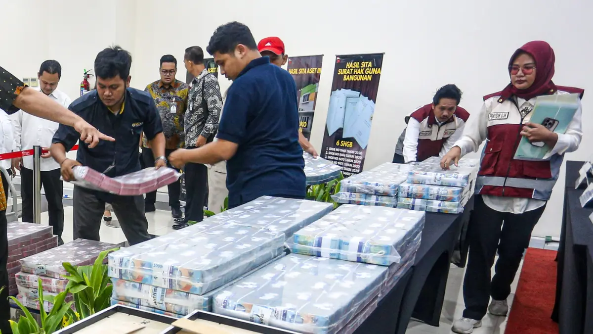 Petugas merapihkan barang bukti hasil penyitaan aset tindak pidana perasuransian PT Jiwa Prolife Indonesia, di Gedung OJK, Jakarta, Kamis (9/7/2026). (Salman Toyibi/Jawa Pos)