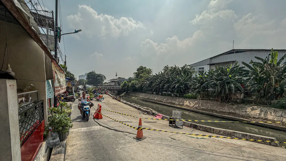 Sejumlah warga melintas di jalan Cinta yang ambles di Pulo Gadung, Jakarta, Kamis (09/07/2026). (Hanung Hambara/Jawa Pos)