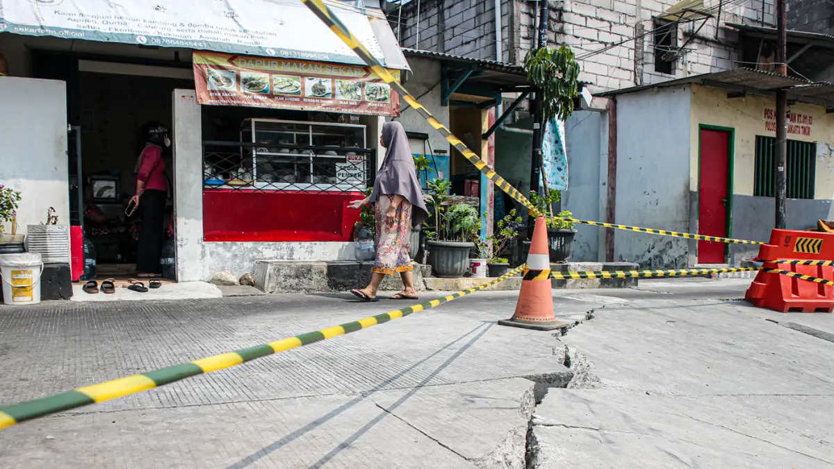 Sejumlah warga melintas di jalan Cinta yang ambles di Pulo Gadung, Jakarta, Kamis (09/07/2026). (Hanung Hambara/Jawa Pos)
