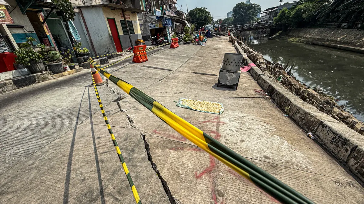 Sejumlah warga melintas di jalan Cinta yang ambles di Pulo Gadung, Jakarta, Kamis (09/07/2026). (Hanung Hambara/Jawa Pos)