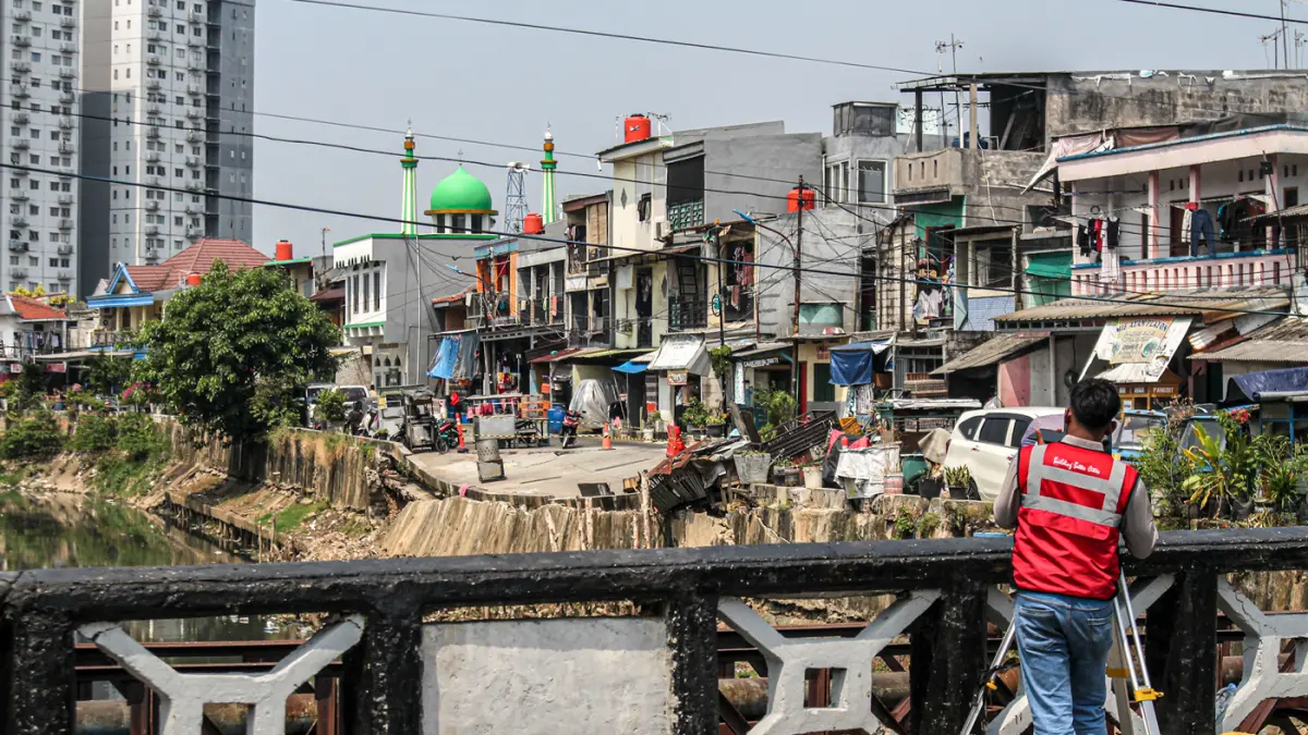 Sejumlah warga melintas di jalan Cinta yang ambles di Pulo Gadung, Jakarta, Kamis (09/07/2026). (Hanung Hambara/Jawa Pos)