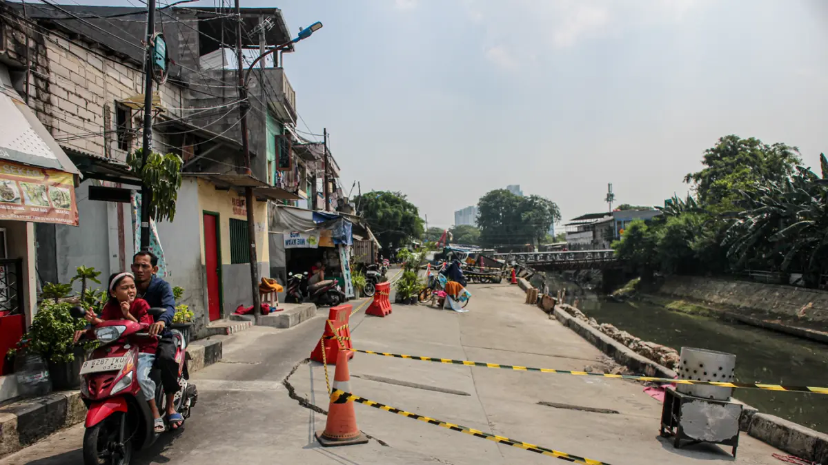 Sejumlah warga melintas di jalan Cinta yang ambles di Pulo Gadung, Jakarta, Kamis (09/07/2026). (Hanung Hambara/Jawa Pos)