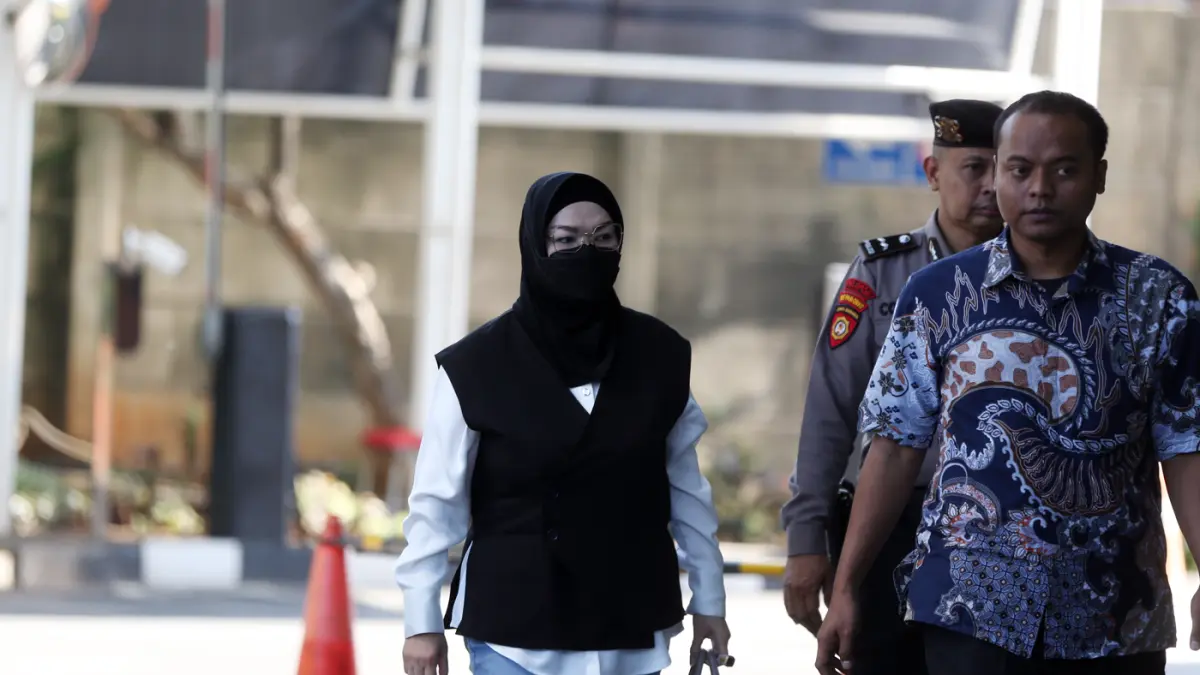 Bupati Sukoharjo Etik Suryani dikawal petugas saat tiba untuk menjalani pemeriksaan di Gedung Merah Putih KPK, Jakarta, Jumat (10/7/2026). (Dery Ridwansah/ JawaPos.com)