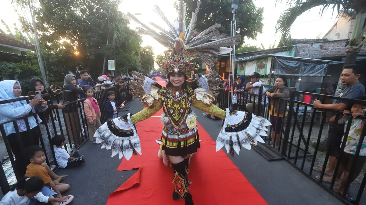 Ribuan warga memadati sepanjang jalan Desa Ngingasrembyong, Kecamatan Sooko, Kabupaten Mojokerto, menyaksikan Ngingas Mojo Carnival yang digelar untuk tahun kedua pada Minggu (12/7/2026). (Sofan/ Jawa Pos Radar Mojokerto)