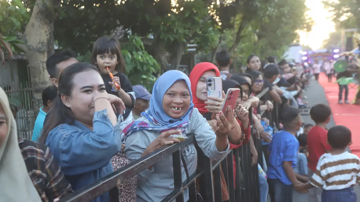 Ribuan warga memadati sepanjang jalan Desa Ngingasrembyong, Kecamatan Sooko, Kabupaten Mojokerto, menyaksikan Ngingas Mojo Carnival yang digelar untuk tahun kedua pada Minggu (12/7/2026). (Sofan/ Jawa Pos Radar Mojokerto)