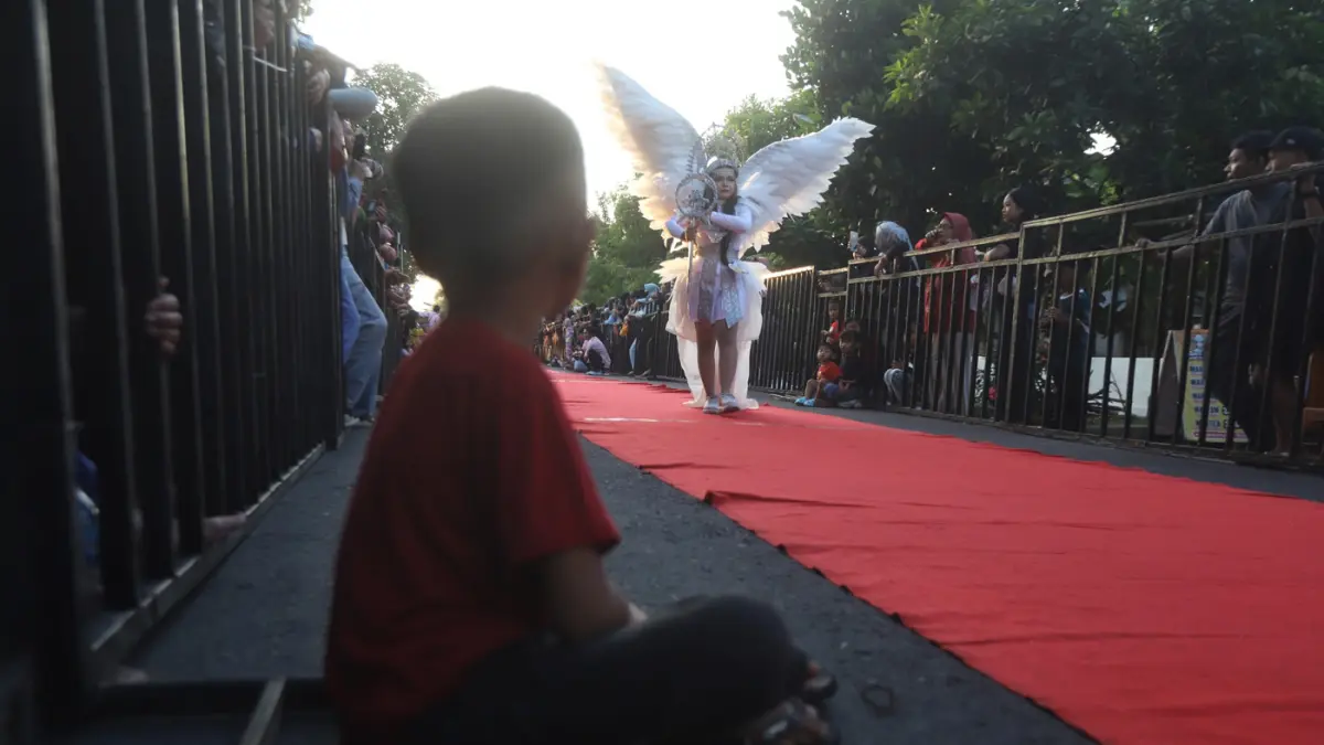Ribuan warga memadati sepanjang jalan Desa Ngingasrembyong, Kecamatan Sooko, Kabupaten Mojokerto, menyaksikan Ngingas Mojo Carnival yang digelar untuk tahun kedua pada Minggu (12/7/2026). (Sofan/ Jawa Pos Radar Mojokerto)