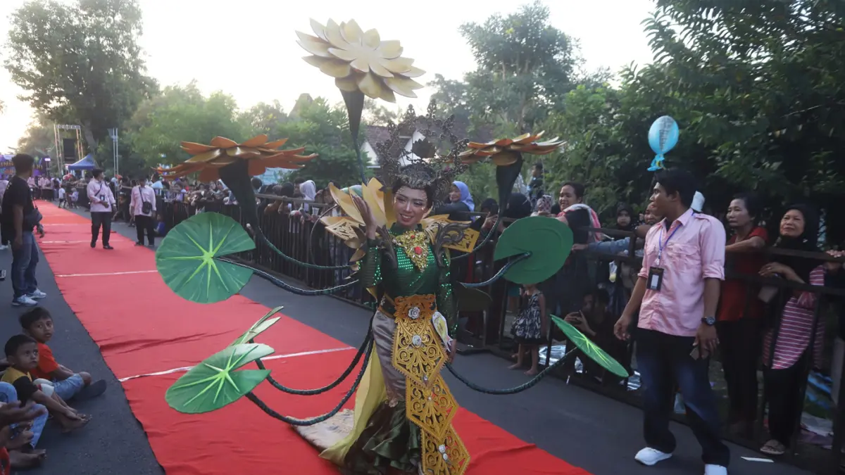 Ribuan warga memadati sepanjang jalan Desa Ngingasrembyong, Kecamatan Sooko, Kabupaten Mojokerto, menyaksikan Ngingas Mojo Carnival yang digelar untuk tahun kedua pada Minggu (12/7/2026). (Sofan/ Jawa Pos Radar Mojokerto)