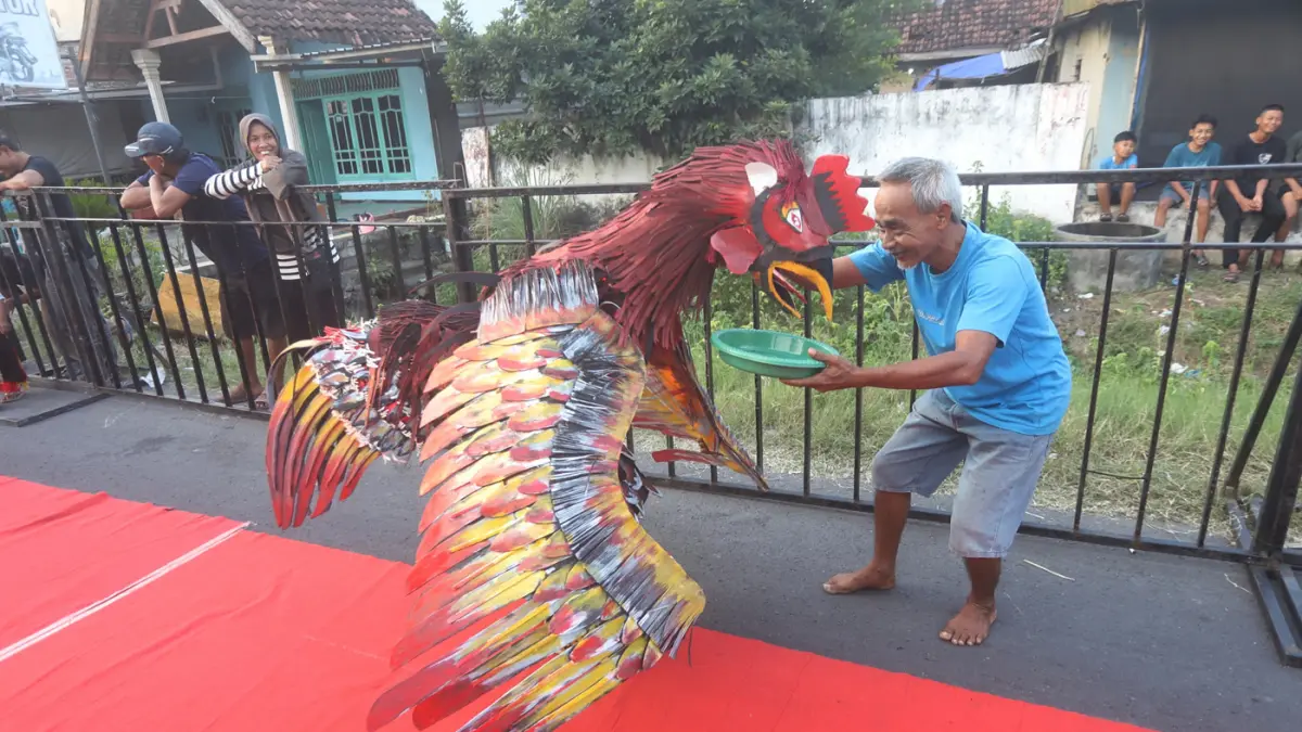 Ribuan warga memadati sepanjang jalan Desa Ngingasrembyong, Kecamatan Sooko, Kabupaten Mojokerto, menyaksikan Ngingas Mojo Carnival yang digelar untuk tahun kedua pada Minggu (12/7/2026). (Sofan/ Jawa Pos Radar Mojokerto)