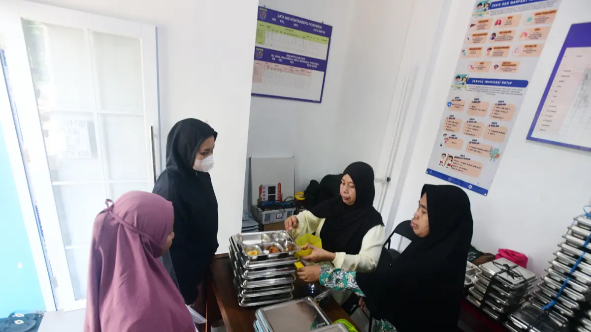 Pembagian makan bergizi gratis (MBG) untuk kelompok 3B (ibu hamil, ibu menyusui, dan balita non-PAUD) di sebuah posyadu di kawasan Limo, Depok, Jawa Barat, Selasa (13/7/2026). (Dery Ridwansah/ JawaPos.com)