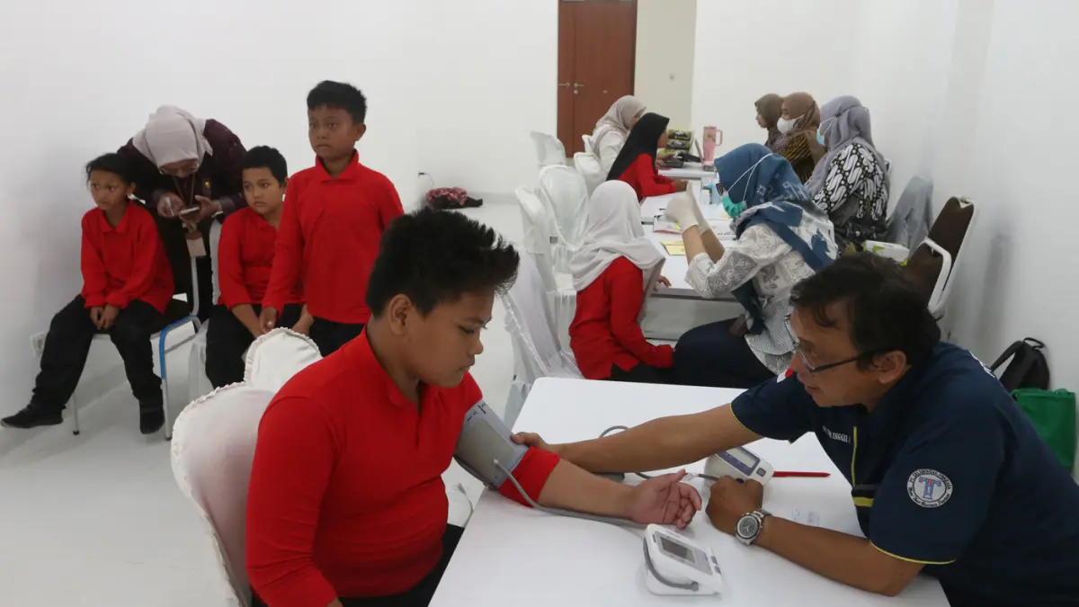 Petugas kesehatan melakukan pemeriksaan kesehatan gratis kepada murid sekolah dasar saat Masa Pengenalan Lingkungan Sekolah (MPLS) di Sekolah Rakyat Terintegrasi 1 Kota Semarang, Jawa Tengah, Selasa (14/7/2026). (Nur Chamim/Jawapos Radar Semarang)