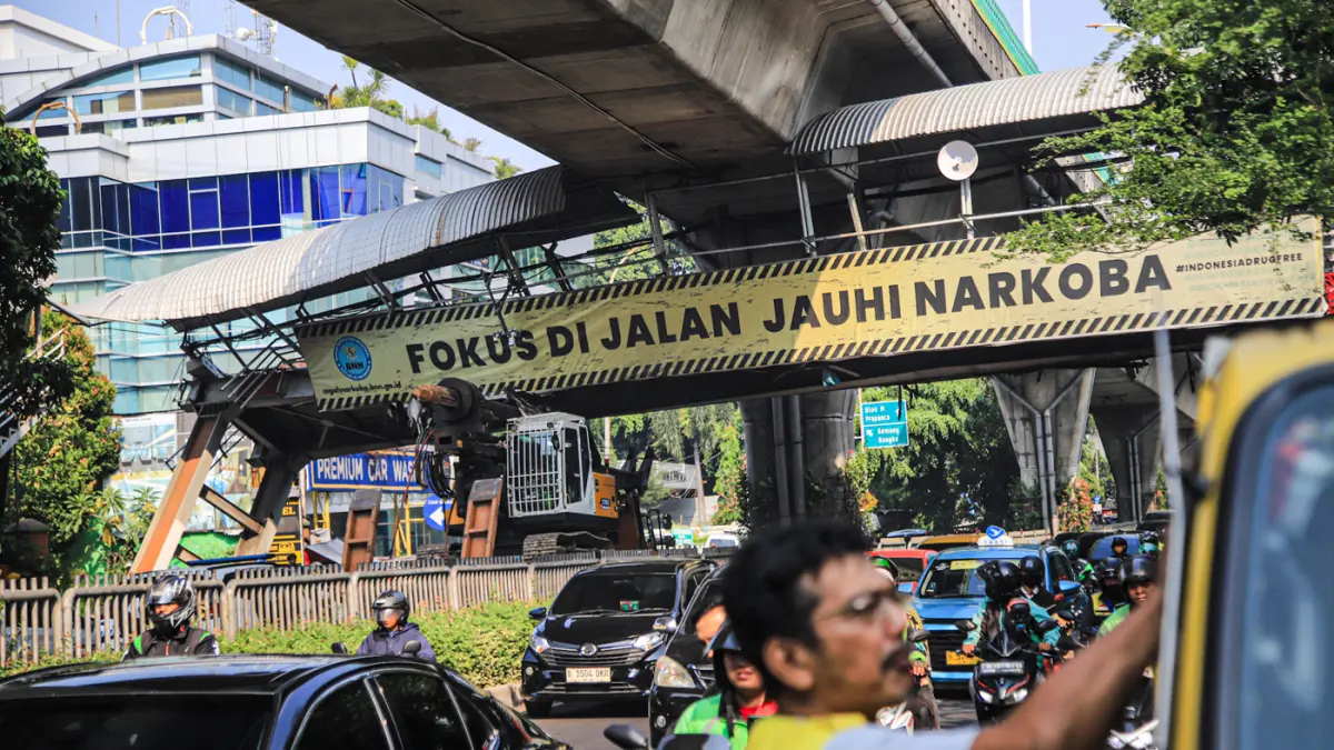 Petugas mengatur kemacetan lalu lintas akibat sebuah truk pengangkut alat berat tersangkut di Jembatan Penyeberangan Orang (JPO) Jalan Tendean, Jakarta, Selasa (14/03/2026). (Hanung Hambara/Jawa Pos)