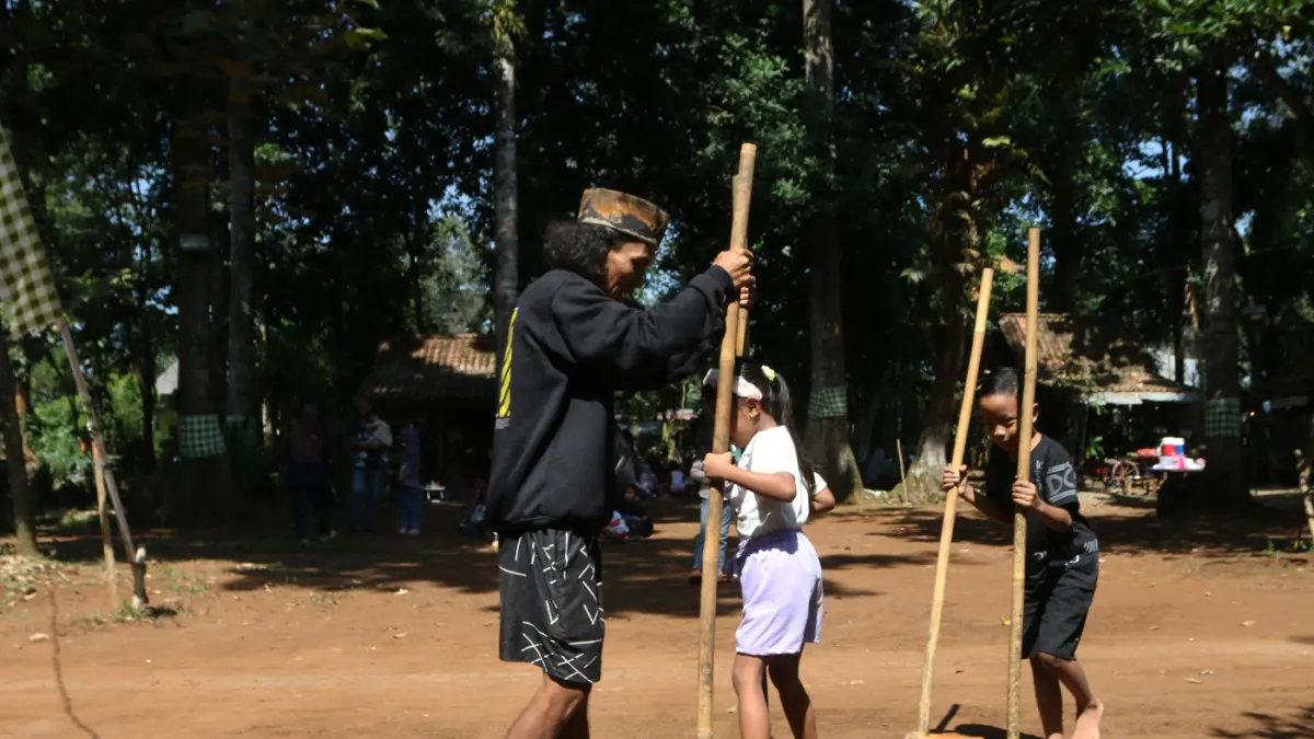 Sejumlah anak bermain Egrang di dampingi pemandu pada kegiatan bertajuk Liburan Sehat Ceria Tanpa Handphone di Sanggar Seni dan Budaya Omah Alas, Desa Wisata Kandri, Gunungpati, Semarang, Jawa Tengah, Kamis (9/7/2026). (Nur Chamim/Jawa Pos Radar Semarang)
