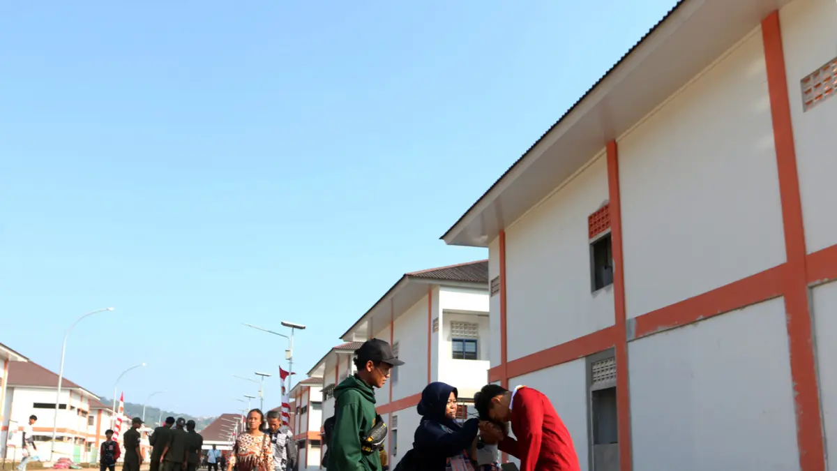 Seorang ibu wali murid Sekolah Menengah Atas (SMA) mengantar anaknya mengikuti Masa Pengenalan Lingkungan Sekolah (MPLS) di Sekolah Rakyat Terintegrasi 1 Kota Semarang, Jawa Tengah, Selasa (14/7/2026). (Nur Chamim/Jawapos Radar Semarang)