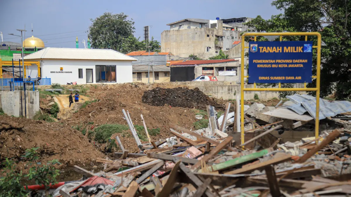 Sejumlah warga berada di reruntuhan bangunan yang terdampak proyek normalisasi Kali Ciliwung di Cawang, Jakarta, Selasa (14/07/2026). (Hanung Hambara/Jawa Pos)