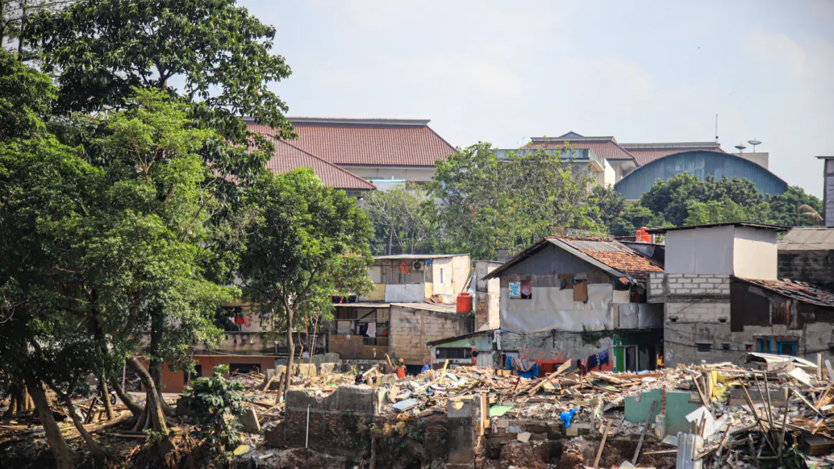 Sejumlah warga berada di reruntuhan bangunan yang terdampak proyek normalisasi Kali Ciliwung di Cawang, Jakarta, Selasa (14/07/2026). (Hanung Hambara/Jawa Pos)