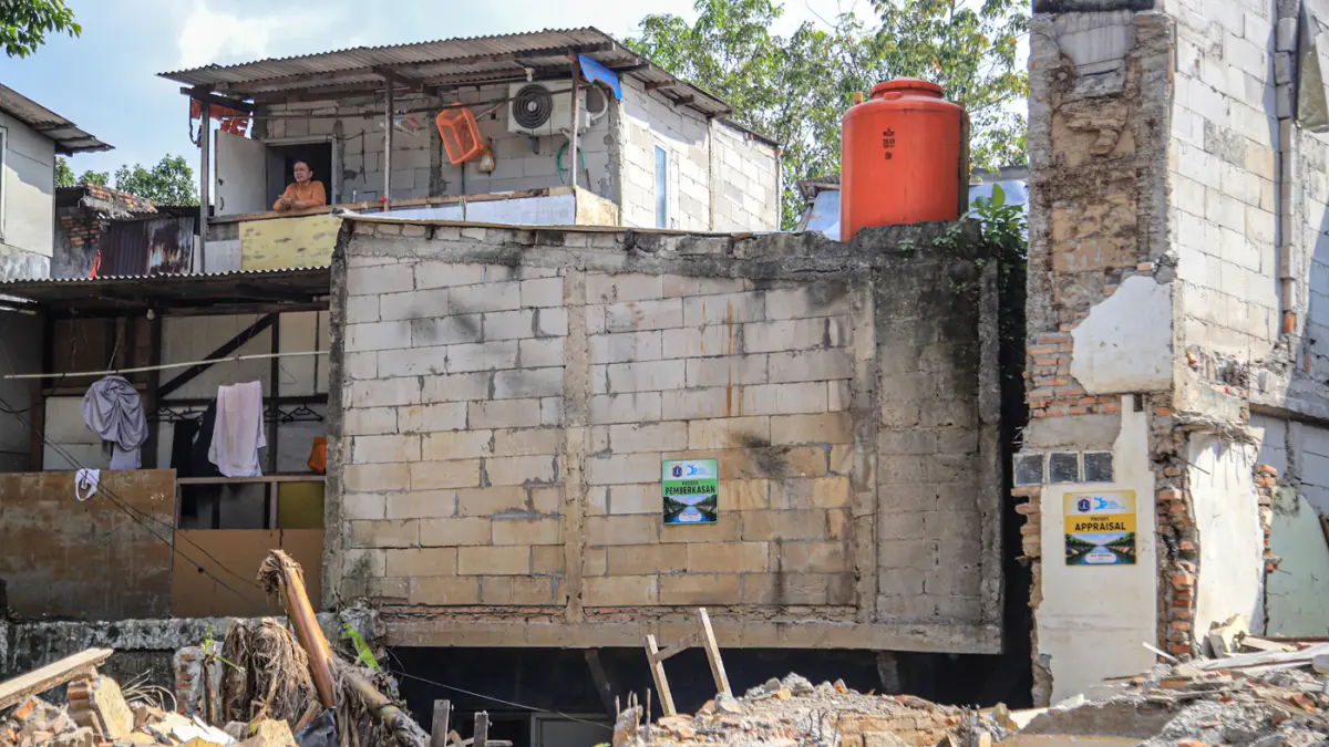Sejumlah warga berada di reruntuhan bangunan yang terdampak proyek normalisasi Kali Ciliwung di Cawang, Jakarta, Selasa (14/07/2026). (Hanung Hambara/Jawa Pos)