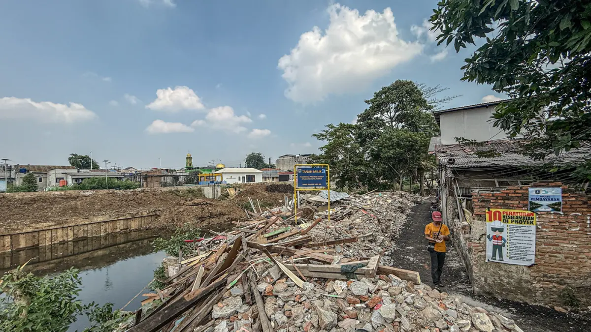 Sejumlah warga berada di reruntuhan bangunan yang terdampak proyek normalisasi Kali Ciliwung di Cawang, Jakarta, Selasa (14/07/2026). (Hanung Hambara/Jawa Pos)