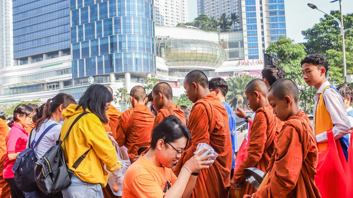 Rombongan Bhikkhu disambut umat Buddha di sepanjang Jalan Mayjen Jonosewojo, Surabaya, Minggu (19/7). (Riana Setiawan/ Jawa Pos)