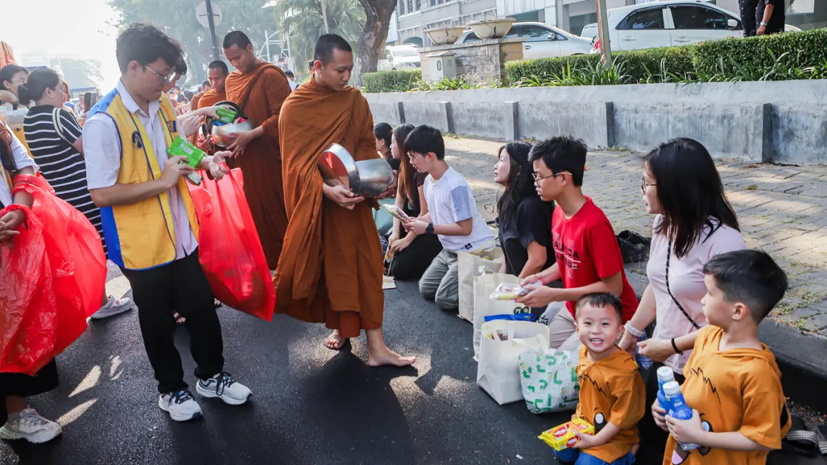 Rombongan Bhikkhu disambut umat Buddha di sepanjang Jalan Mayjen Jonosewojo, Surabaya, Minggu (19/7). (Riana Setiawan/ Jawa Pos)