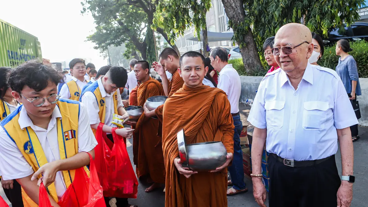 Romo Widya Kusuma dari Vihara Dhammajaya (kanan) bersama rombongan Bhikkhu disambut umat Buddha di sepanjang Jalan Mayjen Jonosewojo, Surabaya, Minggu (19/7). (Riana Setiawan/ Jawa Pos)